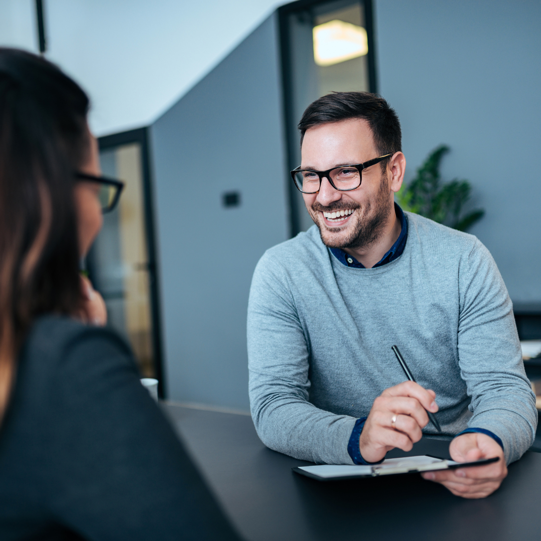 Man speaking to woman at desk
