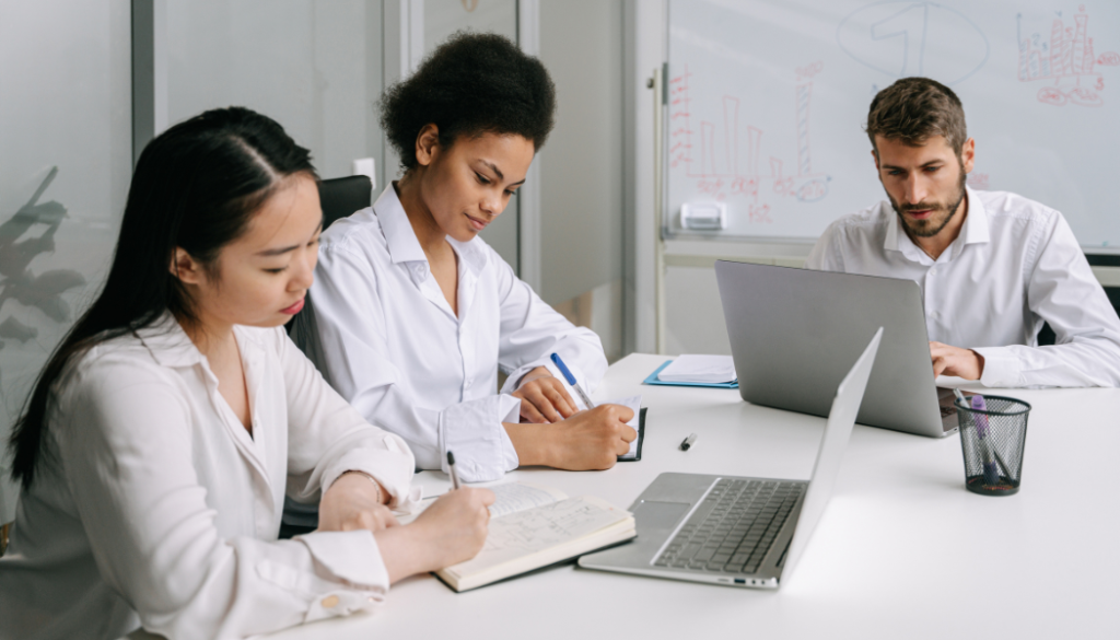 Three team members working heads down at a desk